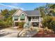 Inviting stilt home featuring a covered front porch and lush landscaping at 601 Foredeck Ln, Edisto Island, SC 29438