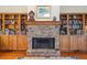 Living room fireplace with brick surround, flanked by custom built-in bookcases and wood flooring at 601 Foredeck Ln, Edisto Island, SC 29438