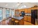 Bright kitchen with island, seating, black appliances, wood cabinetry and a breakfast nook at 601 Foredeck Ln, Edisto Island, SC 29438