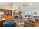 Cozy living room featuring a brick fireplace, built-in bookshelves, and hardwood floors at 601 Foredeck Ln, Edisto Island, SC 29438