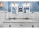 Elegant bathroom with dual sinks, marble countertops, and blue accent walls at 601 Pompano Rd, Edisto Island, SC 29438