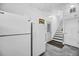 Utility room with white appliances and an entrance to an outside set of stairs at 601 Pompano Rd, Edisto Island, SC 29438