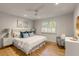 Airy bedroom features a tufted headboard, stylish decor, and a bright window at 7 Logan St # F, Charleston, SC 29401