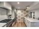 Bright kitchen features stainless steel appliances, white cabinets, and palm-leaf patterned wallpaper at 7 Logan St # F, Charleston, SC 29401