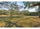 Beautiful backyard view of the lake, mature trees, and a well-maintained lawn create a serene outdoor setting at 728 N Godfrey Park Pl, Charleston, SC 29407
