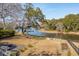 Aerial backyard shot showcasing beautiful waterfront views, mature trees, and colorful Adirondack chairs at 728 N Godfrey Park Pl, Charleston, SC 29407