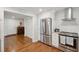 Renovated kitchen with a stainless steel refrigerator, white cabinets, and hardwood floors at 728 N Godfrey Park Pl, Charleston, SC 29407