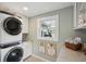 Well-organized laundry room with washer, dryer, storage, and granite countertops at 728 N Godfrey Park Pl, Charleston, SC 29407