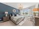 Serene main bedroom featuring a blue accent wall, large window, chandelier, and neutral decor at 742 Meadowbrook Ln, Summerville, SC 29486