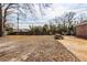 Large, leaf-covered backyard featuring a wooden picnic table and a classic wooden fence at 8 Shrewsbury Rd, Charleston, SC 29407