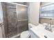 Modern bathroom with a walk-in shower with glass door, white vanity, and stylish fixtures at 8 Shrewsbury Rd, Charleston, SC 29407