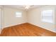 Bright bedroom featuring hardwood floors, ceiling fan, and natural light from two windows at 8 Shrewsbury Rd, Charleston, SC 29407