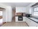 Traditional kitchen with white cabinets, tile flooring, black counters, and stainless microwave at 8 Shrewsbury Rd, Charleston, SC 29407