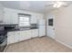 Traditional kitchen with white cabinets, tile flooring, black counters, and stainless microwave at 8 Shrewsbury Rd, Charleston, SC 29407