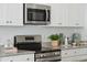 Close-up of a modern kitchen featuring stainless steel appliances, granite countertops, and white cabinetry at 8745 Silver Perch Ln, North Charleston, SC 29420