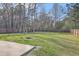 Large backyard featuring a concrete patio, green grass, fire pit, and privacy fence at 94 Dean Dr, Summerville, SC 29483