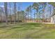 Expansive backyard with a lush lawn, mature trees, and a wood privacy fence at 94 Dean Dr, Summerville, SC 29483