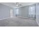Light and airy bedroom boasts neutral carpeting, a ceiling fan, and two large windows with sheer curtains at 94 Dean Dr, Summerville, SC 29483