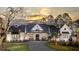 Stunning white farmhouse-style home with a dark roof, detailed black accents, and manicured landscaping at 3945 Bulow Landing Rd, Hollywood, SC 29470