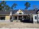 A charming new construction home with a dark metal roof and two-tone yellow and white siding at Lot 20 Bulow Landing Rd, Hollywood, SC 29470