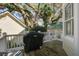 Open wooden back porch featuring white railings, wooden floors, grill and lush backyard at 102 Barnaby St, Charleston, SC 29492