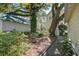 Lush backyard with garden featuring mature trees, flowering plants, and a brick walkway at 102 Barnaby St, Charleston, SC 29492