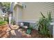 Quaint brick courtyard with a garden bench surrounded by lush greenery and flowering plants at 102 Barnaby St, Charleston, SC 29492