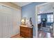 Hallway view into bedroom featuring hardwood floors, a dresser, and a view to a bed with beautiful natural light at 102 Barnaby St, Charleston, SC 29492
