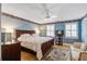 Primary bedroom with a ceiling fan, light blue walls, hardwood floors, and natural light at 102 Barnaby St, Charleston, SC 29492