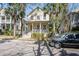 Charming two-story home with front porch and lush landscaping, featuring palm trees and a classic architectural style at 102 Barnaby St, Charleston, SC 29492
