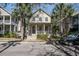 Two-story home with palm trees and a neatly manicured yard, features a welcoming front porch and inviting appeal at 102 Barnaby St, Charleston, SC 29492
