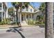 Charming two-story home features a welcoming front porch and well-maintained landscaping, enhanced by mature palm trees at 102 Barnaby St, Charleston, SC 29492