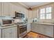 A well lit kitchen featuring stainless steel appliances, updated fixtures and tile backsplash at 102 Barnaby St, Charleston, SC 29492