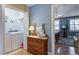 Hallway view into laundry room featuring updated appliances adjacent to hallway with hardwood floors and dresser at 102 Barnaby St, Charleston, SC 29492
