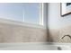 Close-up of a bathroom tub area featuring neutral tiles, a chrome faucet, and a bright window at 1049 Tea Time Dr, Summerville, SC 29485