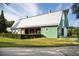 Green barn with a silver roof, surrounded by a lush green lawn and manicured hedges at 109 Marions Oak Dr, Summerville, SC 29486