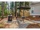 Backyard seating area with table, umbrella, and wooded views at 109 White Pine Way, Summerville, SC 29485