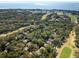 Scenic aerial shot showcases a neighborhood bordered by lush trees, golf course, and coastal waters at 1121 Summer Wind Ln, Seabrook Island, SC 29455