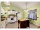 A fully functional kitchen with white appliances, an island, and bright lighting at 114 Tennyson Way, Summerville, SC 29486
