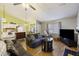 Spacious open-concept living area with couch, television, and kitchen island with hardwood floors at 114 Tennyson Way, Summerville, SC 29486