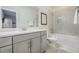 Tiled bathroom features white vanity, framed mirror, toilet, and tub/shower combo with neutral color palette at 1261 Gannett Rd, Mount Pleasant, SC 29464