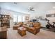 Inviting living room with leather furniture, ceiling fan, large windows, and a workspace, creating a relaxing atmosphere at 1261 Gannett Rd, Mount Pleasant, SC 29464