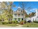 Charming two-story home featuring a double porch and lush landscaping at 1300 Carol Oaks Dr, Mount Pleasant, SC 29466