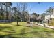 Spacious backyard features lush green grass, mature trees, a swing set, fire pit, and string lights at 1403 Thin Pine Dr, Johns Island, SC 29455