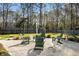 Backyard retreat with Adirondack chairs surrounding a fire pit on a gravel area and mature trees at 1403 Thin Pine Dr, Johns Island, SC 29455