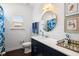 Updated bathroom with a round gold mirror, blue vanity, and a shower with a floral curtain at 1403 Thin Pine Dr, Johns Island, SC 29455