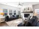 Sunlit living room showcasing large windows, a white brick fireplace, and comfortable blue sofas at 1403 Thin Pine Dr, Johns Island, SC 29455