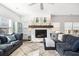 Bright living room featuring a white brick fireplace with rustic mantle and plush blue sofas at 1403 Thin Pine Dr, Johns Island, SC 29455
