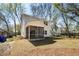 View of the home's backyard featuring a screened porch with a ceiling fan and well-maintained lawn at 1630 Balsam St, Charleston, SC 29407