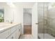 Bathroom with double sinks, stone countertops, a glass-enclosed shower and wood flooring at 1630 Balsam St, Charleston, SC 29407